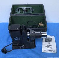 Projector, case, cord, manual visible together
