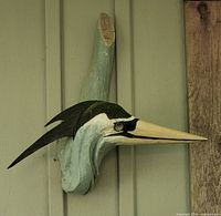 Overall view of carved wooden bird mounted on wall