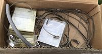 Box containing assorted stainless steel hose clamp straps, assembled clamps, instruction packets, foam tube