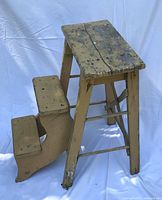 Full view of yellow wooden two-step stool showing top platform and side steps
