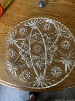 Full view of round clear pressed glass platter on tabletop