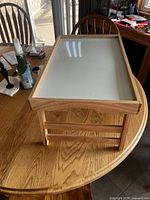 Wooden lap table on kitchen table, legs folded