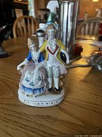Front view of hand-painted porcelain Victorian couple figurine