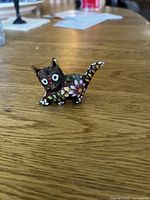 Black-ground cloisonne cat figurine side view