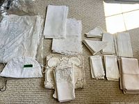 Overall view of assorted white and ivory linens laid out in groups