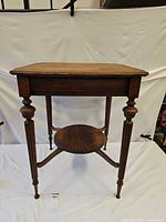 Full view of oak parlor side table showing top, legs, lower shelf