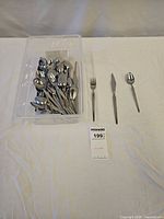 Tub containing assorted forks, knives, spoons