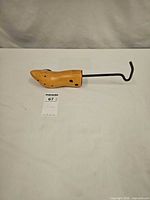 Full view of wooden shoe stretcher with metal handle