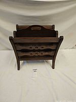 Front view of walnut magazine rack showing handle and ladder sides