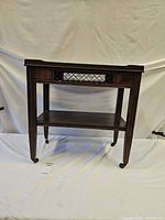 Front angled view showing lattice apron, two tiers, casters