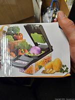 Front of box showing chopper with diced vegetables and accessories