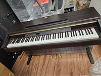 Front view of Yamaha digital piano showing full keyboard, control panel, and three pedals