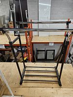 Full view of chrome and black garment rack on platform