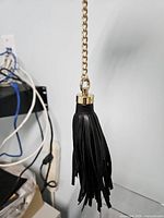 Full view of tassel hanging from gold chain showing overall style and length