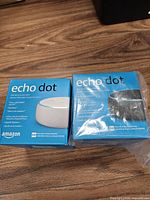 Front view of two Echo Dot boxes, white and charcoal versions