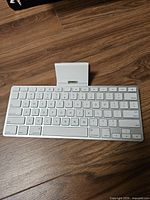 Top view of Apple wireless keyboard with attached white dock/stand