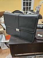 Front view of black faux leather briefcase with key lock