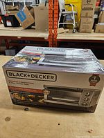 Sealed retail box front showing Black+Decker Natural Convection 4-slice toaster oven