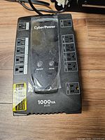 Front/top view showing CyberPower branding, control buttons, outlet layout, 1000VA marking