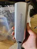 Dermalight 80 branding and silver finish on handheld lamp