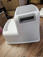Side view of white two-step Dreambaby stool showing handle opening and gray grip pads