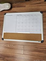 Front view showing calendar grid, cork strip, aluminum frame