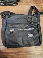 Front view showing compartments, zippers, brand patch