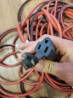 Close-up of male and female plugs showing 3-prong grounding and wear