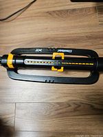 Top view of black and yellow Melnor XT turbo oscillating sprinkler