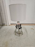 Full view of lamp showing shade and brass-tone geometric base