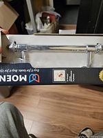 Front of boxed chrome towel bar showing Moen branding