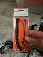 Front view sealed package showing coiled cable and connectors