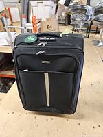 Front view of black POLO spinner suitcase showing exterior pockets and logo plate