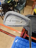 Close-up of iron head showing OPEN OVER SIZE PERIMETER WEIGHTED stamp