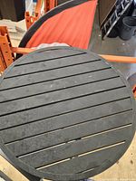 Close-up of slatted resin tabletop showing wear marks