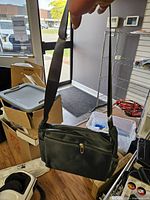 Bag hanging by adjustable strap showing size and shape