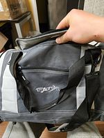 Front view showing logo, handles, strap, color scheme