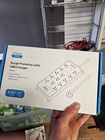 Front of retail box showing illustration of surge protector and brand