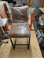 Front view of wrapped brown faux leather counter stool on black metal frame