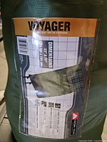 Label on sleeping bag showing Voyager branding, dimensions 33" x 75", plaid interior image
