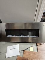 Front view of stainless steel wall-mount electric fireplace with crystal bed