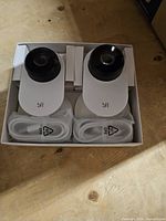 Two cameras and two cables in inner packaging tray