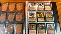 Binder left page showing card backs, right page displaying nine green Magic cards