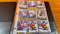 Binder open showing nine Cardfight!! Vanguard cards stored in a nine-pocket sleeve