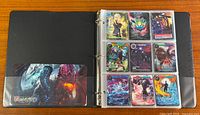 Open binder showing nine stored Force of Will cards in clear pockets and decorative insert.