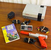 Full bundle laid out showing console, controller, Zapper, power adapter, AV cable, and guide