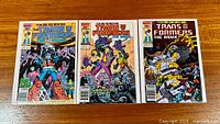 All three bagged comics laid out side by side on wood surface