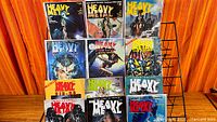 Front view of 12 Heavy Metal magazines arranged on wire rack