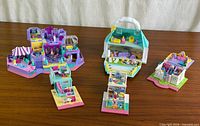 Group shot of four Polly Pocket playsets opened on tabletop