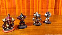 Front view of all four painted warjacks on wooden surface